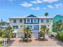 Beautiful townhomes with bright, colorful facades and private garages in a tropical setting at 100 Windrush Blvd # 1, Indian Rocks Beach, FL 33785