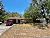 Charming single story home with mature trees, front lawn, and an attached two-car garage at 11272 Portsmouth St, Spring Hill, FL 34609