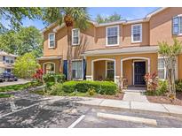 Two-story tan townhome with a well-manicured lawn and a beautiful palm tree in the front yard at 2529 Harn Blvd # 2, Clearwater, FL 33764