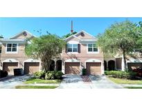 Charming townhome featuring a private garage, arched entryway, and neatly kept landscaping at 26514 Chimney Spire Ln, Wesley Chapel, FL 33544