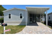 Charming home exterior features a screened-in porch, paved driveway, and well-maintained lawn at 3722 Binnacle Dr, Tampa, FL 33611