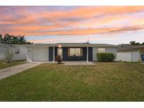 Charming single-story home featuring a well-maintained lawn, attached garage and inviting front patio at 3813 Luma Dr, Holiday, FL 34691