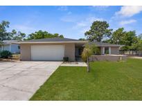 Charming single-story home with a two-car garage and well-manicured lawn at 5193 Higate Rd, Spring Hill, FL 34609