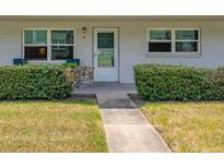 Charming condo front entrance with well maintained landscaping and a gray stone pathway and windows at 5267 81St N St # 8, St Petersburg, FL 33704