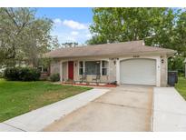 Charming one-story home features a well-maintained front lawn and an attached garage at 8600 Village Mill Row, Hudson, FL 34667