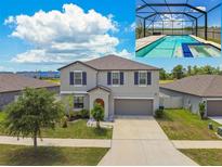 Two-story home featuring a private screened-in pool and a well-manicured lawn at 11504 Sage Canyon Dr, Riverview, FL 33578