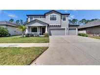 Inviting two-story home with a well-manicured lawn, complemented by a spacious driveway and a two-car garage at 12134 Creek Preserve Dr, Riverview, FL 33579