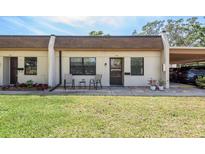 Charming single-story townhome with well-maintained lawn and cozy front seating area near covered parking at 1472 Mission Hills Blvd # 24F, Clearwater, FL 33759
