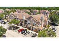 Exterior view of a condominium with multiple units and a parking lot with several cars at 18017 Villa Creek Dr # 18017, Tampa, FL 33647