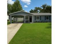 Charming home with a well-manicured front yard, covered parking, and inviting curb appeal at 2205 N Grady Ave, Tampa, FL 33607