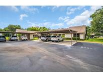 Exterior of condo featuring assigned carport parking and guest parking spaces on a sunny day at 2506 Laurelwood Dr # 4C, Clearwater, FL 33763