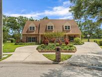 Beautiful brick two-story home with a circular driveway, mature landscaping, and a well-maintained lawn at 4033 Priory Cir, Tampa, FL 33618