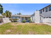 Charming light blue single-story home with a unique stone chimney and well-maintained front lawn at 621 85Th N Ave, St Petersburg, FL 33702