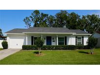 Charming single-story home with a manicured lawn, vibrant blue front door, and attached garage, offers classic curb appeal at 7229 Northbridge Blvd, Tampa, FL 33615