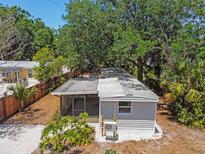 An aerial view of the home with gray siding and a screened-in porch surrounded by trees at 850 Center Ave, Brandon, FL 33511