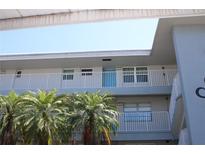Condominium building featuring white railings, light gray exterior and palm trees on the grounds at 9950 47Th N Ave # 311, St Petersburg, FL 33708
