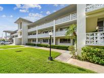 Well maintained multi-story building with lush green lawn and decorative white concrete railing at 1235 S Highland Ave # 2-207, Clearwater, FL 33756