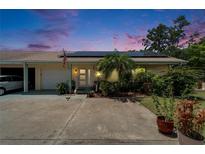 Charming single-story home with solar panels, lush landscaping, and attached garage under a beautiful twilight sky at 1349 New Bedford Dr # 6, Sun City Center, FL 33573
