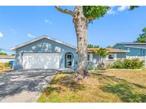 Charming single Gathering home with a two-car garage and mature tree in front yard at 14884 Cromwell Dr, Clearwater, FL 33764
