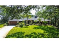 Charming single-story home with lush landscaping, manicured lawn and a prominent brick entrance at 17519 Drake Ct, Lutz, FL 33559