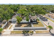 Aerial view of a charming single-story home featuring a manicured lawn and surrounded by a pristine white fence at 2322 21St S St, St Petersburg, FL 33712