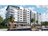 Modern waterfront resort showcasing multiple stories, private balconies, and lush landscaping with palm trees at 411 E Shore Drive # 201, Clearwater Beach, FL 33767