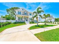 Charming two-story home with a well-manicured lawn, lush landscaping and long driveway at 4710 W El Prado Blvd, Tampa, FL 33629
