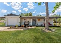 Charming single-story home featuring a well-manicured lawn, fresh landscaping, and inviting front porch at 7494 7Th N St, St Petersburg, FL 33702