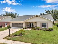 Charming single-story home featuring a well-manicured lawn, neutral paint, an attached garage, and a covered front porch at 9335 Stonewall, New Port Richey, FL 34655