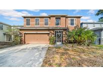 Two-story home with a two car garage, covered porch entry and some landscaping at 10505 Boyette Creek Blvd, Riverview, FL 33569