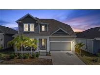 Charming two-story home featuring a covered front porch, well-maintained lawn, and an attached two-car garage at 1432 Gopher Loop, Tarpon Springs, FL 34689