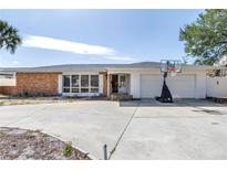 Charming single-story home with a brick facade, bright white trim, and a spacious two car garage at 2140 Dolphin S Blvd, St Petersburg, FL 33707