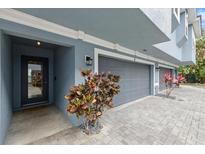Stylish townhouse showing the garage door, front door, and brick paver driveway at 3111 W De Leon St # 8, Tampa, FL 33609