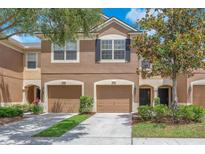 Inviting two-story townhome featuring a two-car garage and manicured landscaping at 4862 Pond Ridge Dr, Riverview, FL 33578