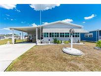 Charming home featuring an inviting covered carport and well-manicured front yard with beautiful landscaping at 5646 Cheyenne St, Zephyrhills, FL 33542