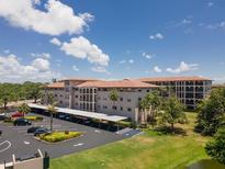 Exterior of Golfview Condominiums featuring covered parking, lush landscaping, and building architecture at 6150 Gulfport S Blvd # 306, Gulfport, FL 33707