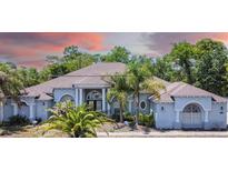 Stunning single Gathering home with palm trees, meticulously landscaped front yard, and an open porch at 7285 Nightwalker Rd, Weeki Wachee, FL 34613