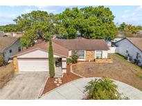 Charming single-story home with a stone accent, well-kept lawn, and a circular driveway at 11318 Stoneybrook Path, Port Richey, FL 34668