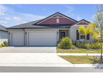 Charming single-Gathering home with a manicured lawn, brick driveway, and a three-car garage at 12572 Bergstrom Bay Dr, Riverview, FL 33579