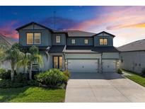 Two-story home showcasing lush landscaping, well-manicured lawn, and a three-car garage at 13071 Willow Grove Dr, Riverview, FL 33579