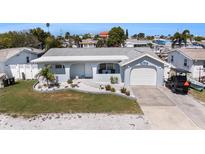 Charming single-story home featuring a well-maintained lawn and attached one-car garage at 13401 Neptune Dr, Hudson, FL 34667