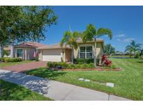 Beautiful single-story home with mature landscaping, brick driveway, and tile roof in an attractive community at 16139 Coquina Bay Ln, Wimauma, FL 33598