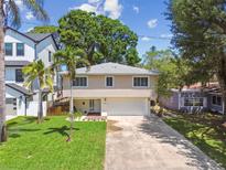 Inviting two-story home featuring a well-maintained lawn, palm tree, and a spacious driveway leading to a two-car garage at 1735 Maryland Ne Ave, St Petersburg, FL 33703