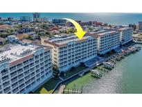 Stunning aerial view of condo complex with boat slips, beautiful landscaping and waterfront access at 17735 Gulf Blvd # 202, Redington Shores, FL 33708