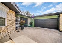 A spacious driveway leads to an attached garage, complemented by decorative plants, enhancing the home's curb appeal at 307 Orangewood Ln, Largo, FL 33770
