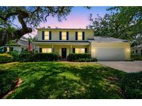 Charming two-story home features a manicured lawn, welcoming front porch and attached two car garage at 3212 W Villa Rosa St, Tampa, FL 33611