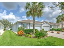 Charming single-story home features a lush, landscaped front yard with vibrant plants and a well-manicured lawn at 32829 Woodthrush Way, Wesley Chapel, FL 33545