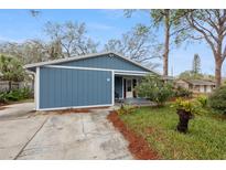 Cozy single-story home featuring wood siding, a well-maintained lawn, and mature trees at 7247 Oelsner St, New Port Richey, FL 34652