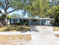Charming single-story home featuring a covered carport and mature shade trees on a well-manicured lawn at 920 16Th Sw Ave, Largo, FL 33770