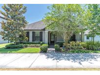 Charming single-story home with manicured lawn, lush trees, and beautiful front garden at 12462 Rangeland Blvd, Odessa, FL 33556